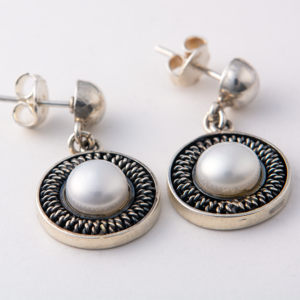 Handcrafted sterling silver drop earrings with freshwater pearls and twisted detailing