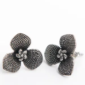 Handcrafted stud earrings that hold an orchid flower. Both flowers have 3 petals formed with are raised circles and the centers a detailed mini flower with 5 petals.