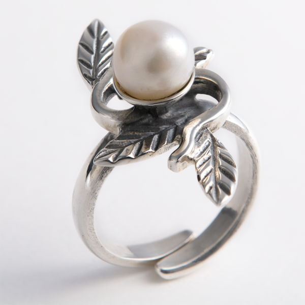 Handmade sterling silver ring featuring a luminous pearl and intricate leaf details.